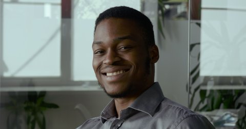 Smiling african american millennial professional man looking at camera. Happy confident handsome smart young adult entrepreneur, leader, manager posing in office. Close up face view business portrait