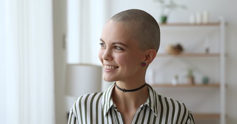 Young bald woman wear earrings stylish choker and striped shirt pose smile look at camera. Recovered cancer patient begin new life after oncology disease. Fashionable female head shot portrait concept