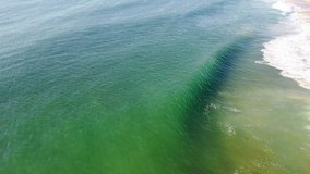 Pull Back Overhead Aerial Drone Shot of bodyboarder in ocean at beach