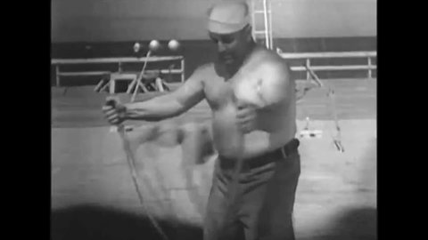 CIRCA 1910s - A stunt man or strongman is shot with a cannonball from a cannon.