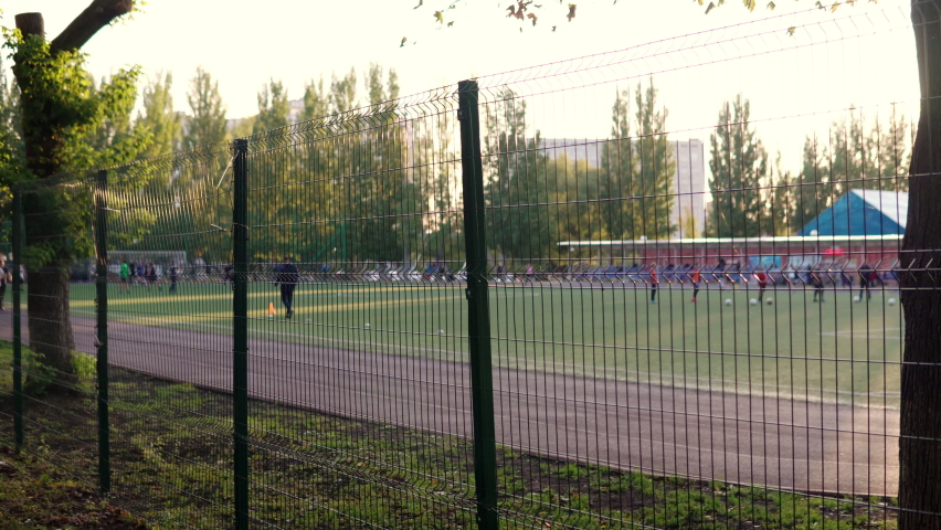 Football field with a running track. People on the playground go in for sports and play football