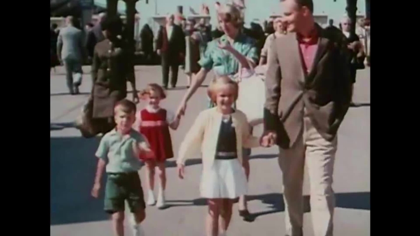 CIRCA 1960s - Dozens of people pour into the entrance of the New York World's Fair, including families, a boy scout troop, and teachers in 1964.