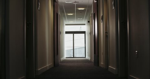 Man talking on phone in office corridor / Hull, England, UK