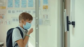 Unhealthy teenager schoolboy approaching for temperature check on computer scanning device coughing and walking away. Coronavirus pandemic. - Powered by Shutterstock - Get 15% off with code: PIKWIZARD15