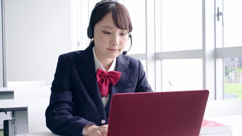 Asian female high school student taking online lessons.