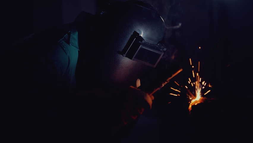 Metal welder working with arc welding machine to weld steel at factory while wearing safety equipment. Metalwork manufacturing and construction maintenance service by manual skill labor concept. | Shutterstock HD Video #1059765575