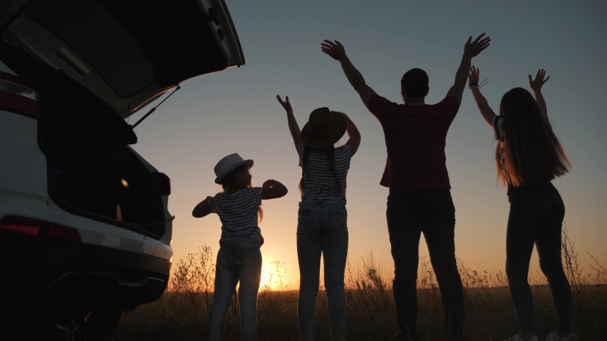 Beautiful family silhouette. Many people hands up together. People lifestyle concept of family travel by car. Happy family resting together at sunset. | Shutterstock HD Video #1059765869