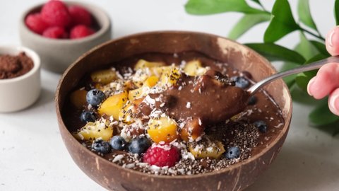 Vegan carob chocolate smoothie with superfood toppings. Eating healthy smoothie bowl