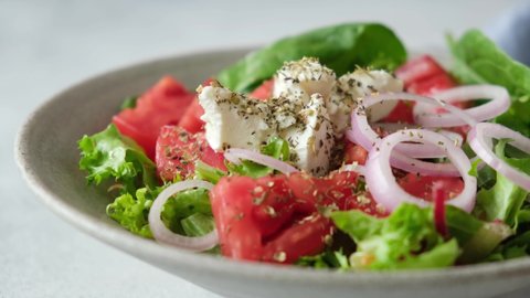 Pouring olive oil on greek salad. Salad dressing extra virgin olive oil