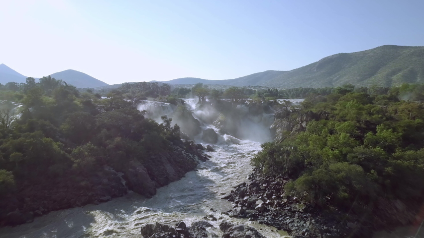 beautiful Epupa Falls on the Kunene River in Northern Namibia and Southern Angola border. Sunrise sunlight in water mist. This is africa. Beautiful landscape. Royalty-Free Stock Footage #1059766190