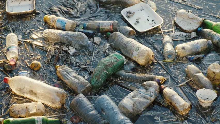 Plastic bottles in sea. Plastic bags. Garbage. Ecological catastrophe, save the planet. Blue calm sea water. Trash.  Floating rubbish floats in the sea. Construction ladle Royalty-Free Stock Footage #1059773027