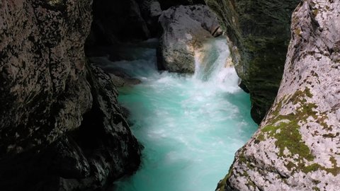 Dolly in of stunning Soca River running fast in a rocky landscape scenario near Boka Waterfall, Slovenia