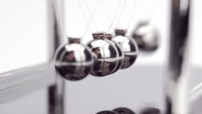 Newton's Cradle metal balls on white background, swinging metal balls, Macro shot. Close up.