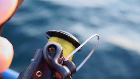 Close-up of a trolling reel against the sea. Fishing and fishing accessories.sea fishing in summer