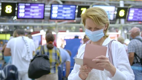 close-up. masked woman with passport and boarding pass at the airport. Adlı Stok Video