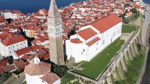 St. George's Parish Church with Piran city in background. Aerial pedestal shot
