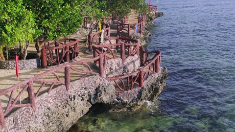 Wide angle dolly out drone shot of walkway in resorts and coastlines/seaside in Boracay island in the Aklan region of Phillipines during the day
