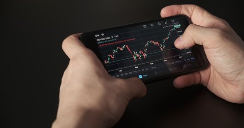 Stock Exchange, Trading Online, Trader Working With Smartphone on Stock Market Trading Floor. Man Touch Screen Reading Financial News, Browse Foreign Exchange Market Data, Chart Forex.