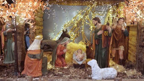 Holy night and Jesus Christ Nativity scene, illuminated christmas decoration of Jesus birth in manger with Mary, Joseph, shepherds the lamb and coming kings. Religious scene of christmas figurines
