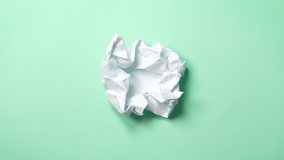 stop motion animation paper wrinkles making a paper ball. Mint green background. A paper ball spreads making a blank sheet and folds again until it disappears. - Powered by Shutterstock - Get 15% off with code: PIKWIZARD15