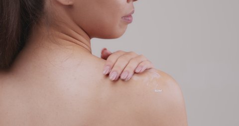 Body care concept. Close up of young woman fondling her naked shoulder