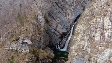 Aerial Follow Shot Of Savica Waterfall Flowing Down Mountainside