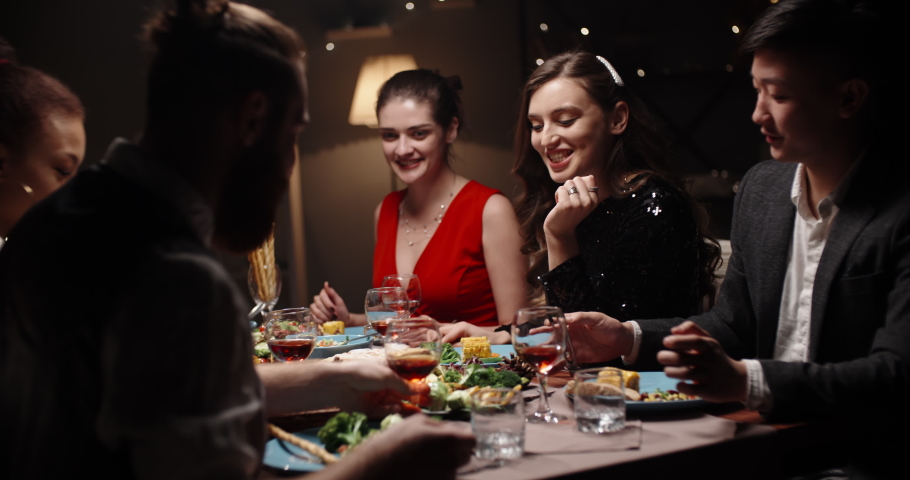 Group of cheerful multiethnic student friends are celebrating birthday together. Positive people having dinner for event, eating vegan mediterranean food 4k footage Royalty-Free Stock Footage #1059834563
