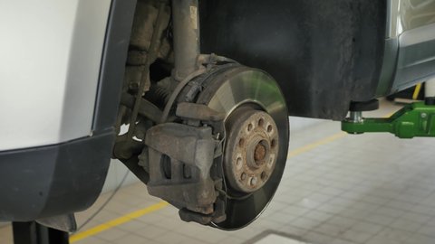 Measuring the Thickness of Brake Disc and Mechanical Calipers. Mechanic is Working in Auto Service.