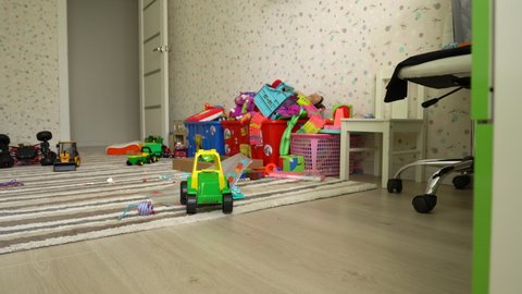 Scattered toys on the floor in the children's room, a mess in the nursery in the absence of children