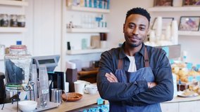 Portrait of smiling man running local coffee shop standing behind counter - shot in slow motion - Powered by Shutterstock - Get 15% off with code: PIKWIZARD15