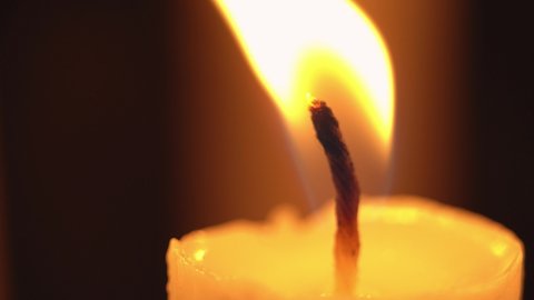 Macro view of extinguishing a candlelight by blowing it out, extreme close up view footage of blowing out a candle in the dark.