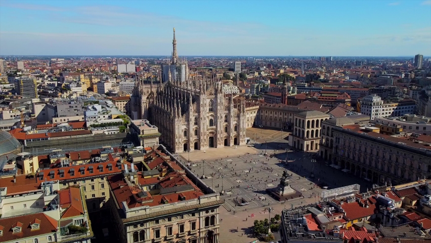 Aerial view of Piazza Duomo in front of the gothic cathedral in the center. Drone view of the gallery and rooftops during the day. Flight over the city. People in the city. Milan. Italy, Royalty-Free Stock Footage #1059862925