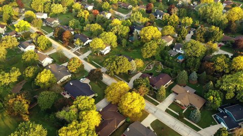 Aerial footage of  an American town  showing typical suburban housing estates with rows of houses, taken on a sunny day using a drone. Establishing shot of typical suburban neighborhood