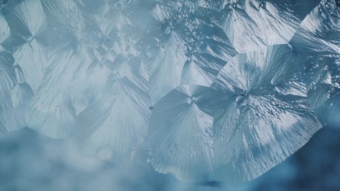 Beautiful freezing ice crystal flowers on window with blue background, macro
