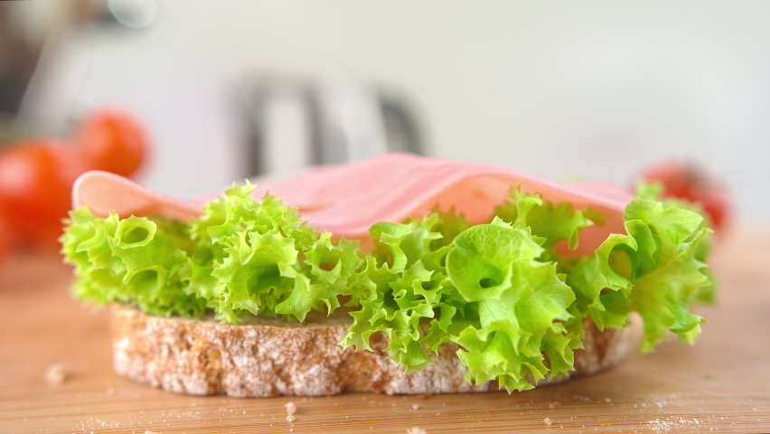 Slice of Cheese Falling onto Sandwich with Ham and Lettuce in 1000fps Royalty-Free Stock Footage #1059863903