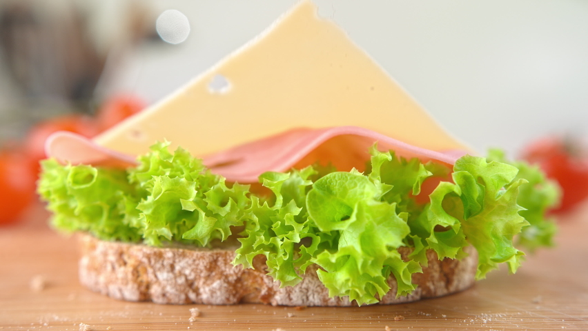 Slice of Cheese Falling onto Sandwich with Ham and Lettuce in 1000fps | Shutterstock HD Video #1059863903