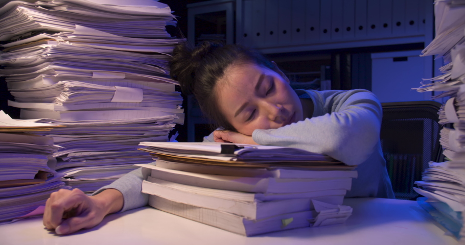 Exhausted asian business woman putting documents on desk cover with stack of paperwork. Tired alone girl looking at paper and lay down on pile of sheets while working hard at late night at home.
 | Shutterstock HD Video #1059865610