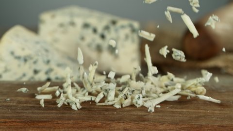 Super Slow Motion Shot of Grated Blue Cheese Falling on Wooden Board at 1000 fps.