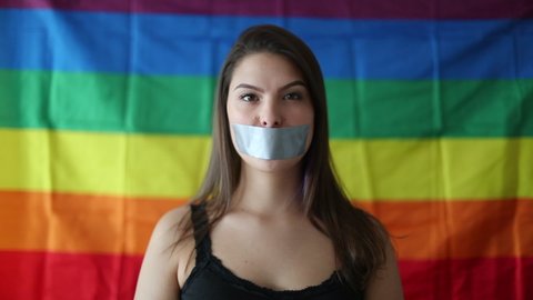 Woman putting mouth tape. LGBT freedom concept. Censored unable to speak, censorship