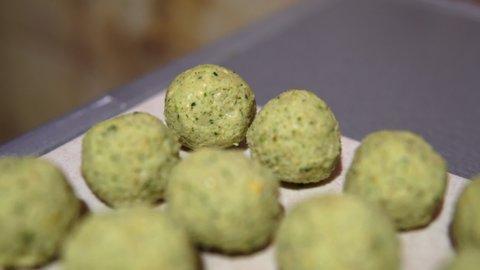 Fresh falafel - balls of chickpea, herbs and vegetables are ready to be roasted in oil. Popular vegan dish. 