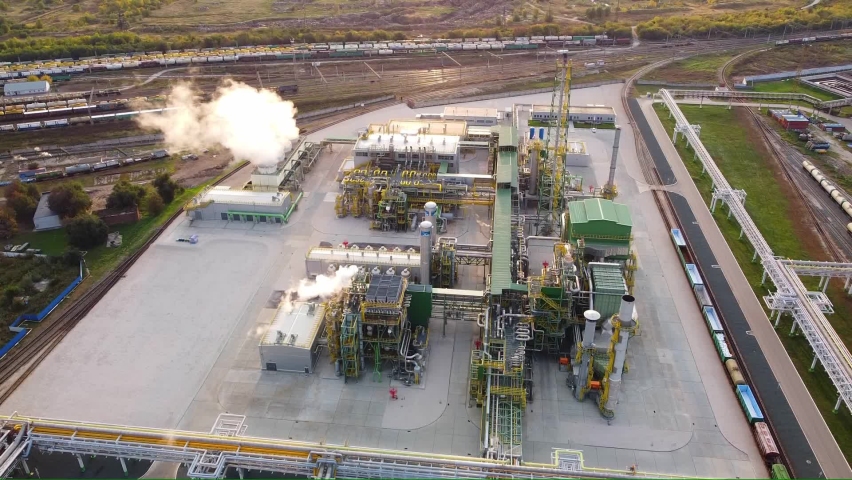 Drone flight over a chemical plant for the production of ammonia. Tall pipes, smoke. Aerial view.