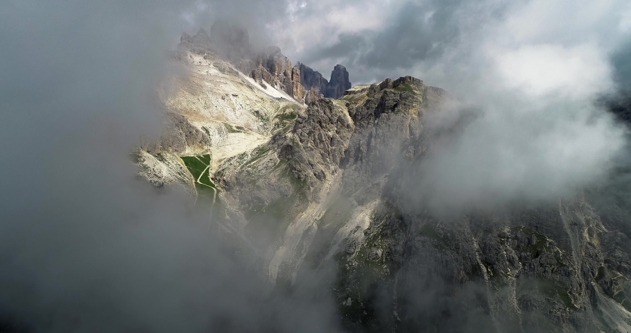 Peak of Cinque Torri mountains in Italy, in the middle of the clouds. Beautiful landscape scenery of mountains - aerial view with a drone 4K