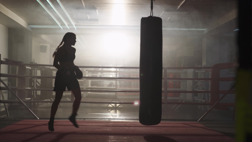 Kickboxing, woman fighter trains his punches, beats a punching bag, training day in the boxing gym, strength fit body, the girl strikes fast. | Shutterstock HD Video #1059897722