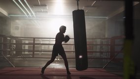 Kickboxing, woman fighter trains his punches, beats a punching bag, training day in the boxing gym, strength fit body, the girl strikes fast. - Powered by Shutterstock - Get 15% off with code: PIKWIZARD15