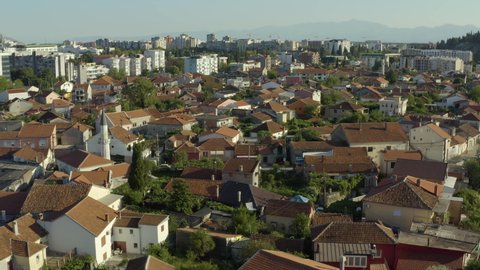 Aerial view of Podgorica capital city of Montenegro. Drone shot on a panorama of the old city. Houses with a tiled roof and urban landscape on the background.