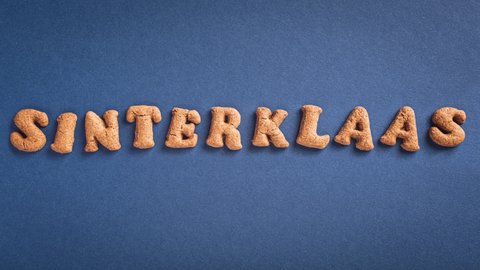 Stop motion animation. Sinterklaas is coming soon, 4K. Dutch holiday St Nicholas day concept with letters traditional cookies, kruidnoten on blue background with copy space. Top view.