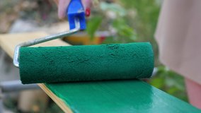 Close up video of human hand paints an old wooden board with green paint. Renovation, Housework, Restoration