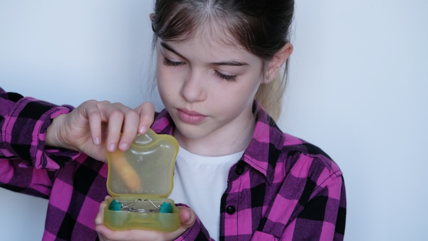 Little / young girl puts on a dental orthodontic retainer. Dentistry and orthodontics, concept | Shutterstock HD Video #1059904208