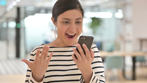 Portrait of Excited Indian Woman Celebrating Success on Smartphone 