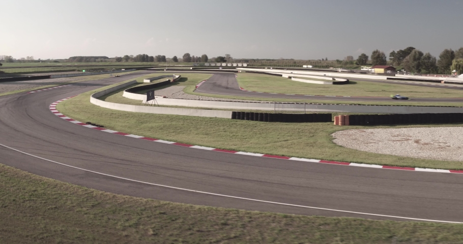 Aerial over curve of formula 1 racing track with cars speeding and drifting at high pace on a bright sunny day. Royalty-Free Stock Footage #1059911489